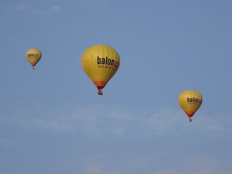 Tři žluté balóny na cestě
