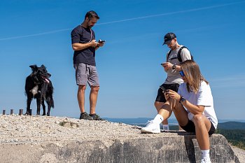 Lidé z města na výletě v přírodě a jeden šťastný pes